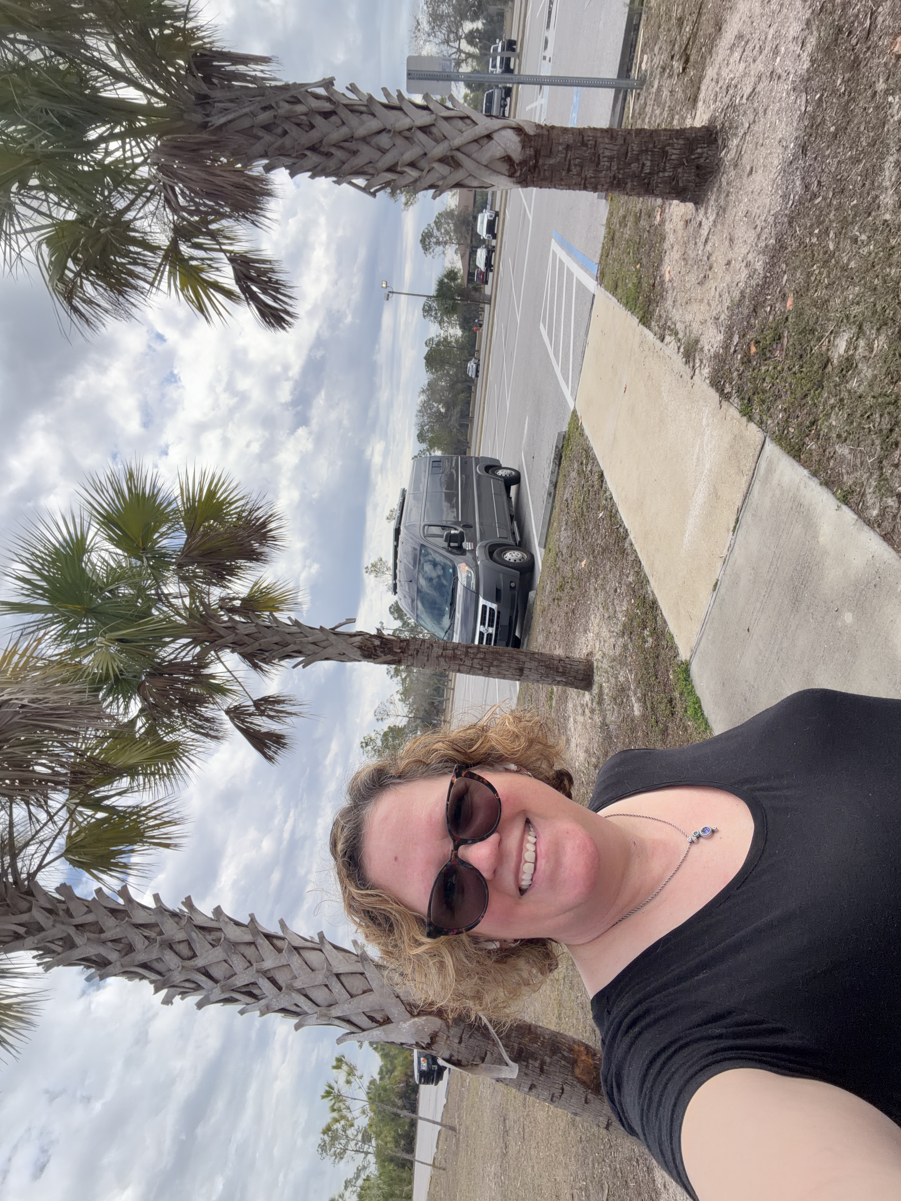 Andrea Michalek outdoors with palm trees and her van