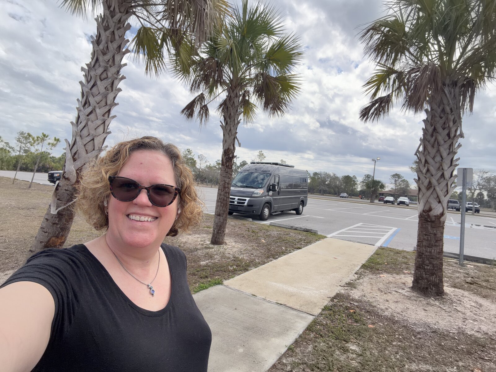 Andrea Michalek outdoors with palm trees and her van