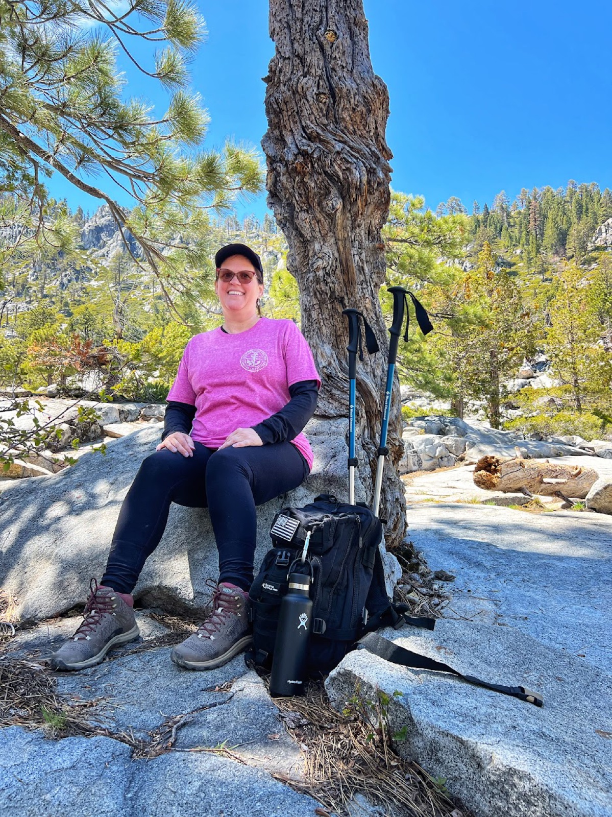 Andrea Michalek hiking, sitting on a rock in the mountains